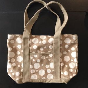 Small-ish tan canvas tote with white polkadots.